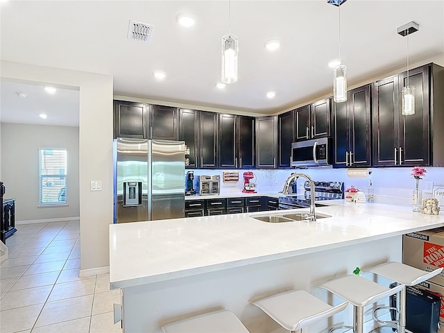 4850 Coral Castle Dr, Kissimmee, FL 34746 - kitchen featuring stainless steel appliances, light tile patterned floors, a peninsula, light countertops, and pendant lighting