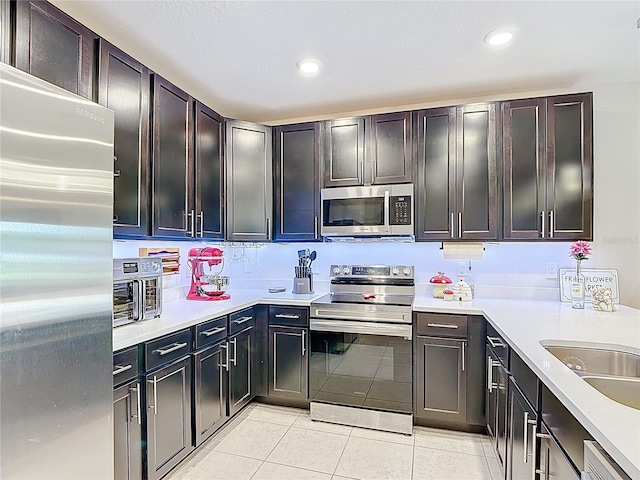 4850 Coral Castle Dr, Kissimmee, FL 34746 - kitchen with appliances with stainless steel finishes, light tile patterned floors, light countertops, and recessed lighting