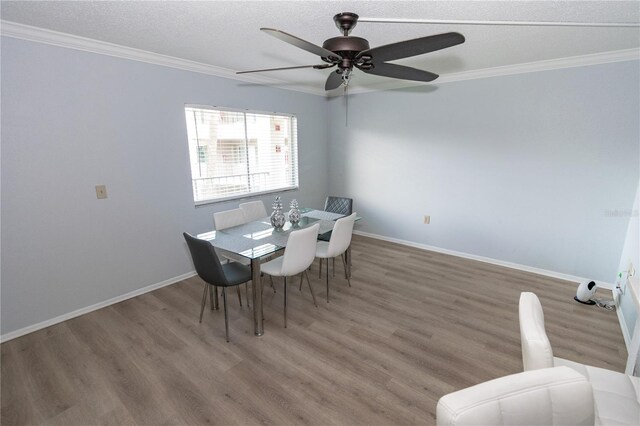 139 Oyster Bay Cir Unit 200, Altamonte Springs, FL 32701 - dining room featuring crown molding, wood finished floors, a ceiling fan, baseboards, and a textured ceiling