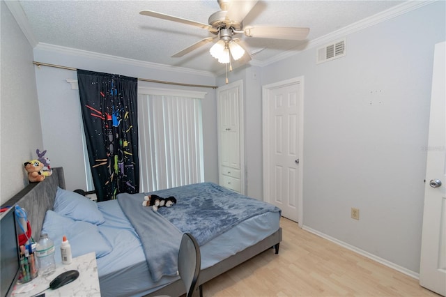 139 Oyster Bay Cir Unit 200, Altamonte Springs, FL 32701 - bedroom featuring light wood-style floors, ornamental molding, baseboards, a ceiling fan, and a textured ceiling
