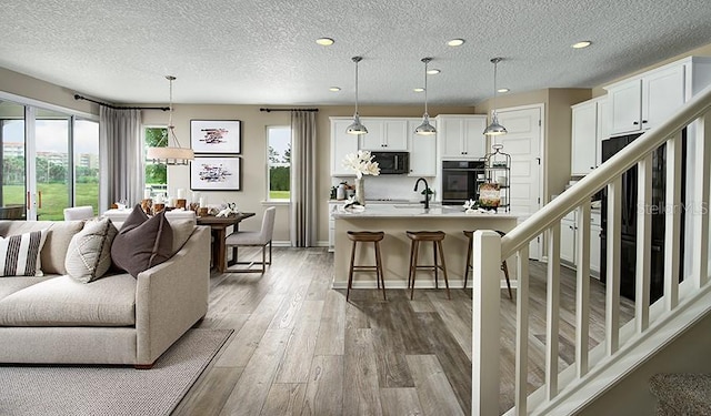 223 Thornberry Way, Palm Coast, FL 32164 - living room with wood finished floors, recessed lighting, a textured ceiling, and baseboards