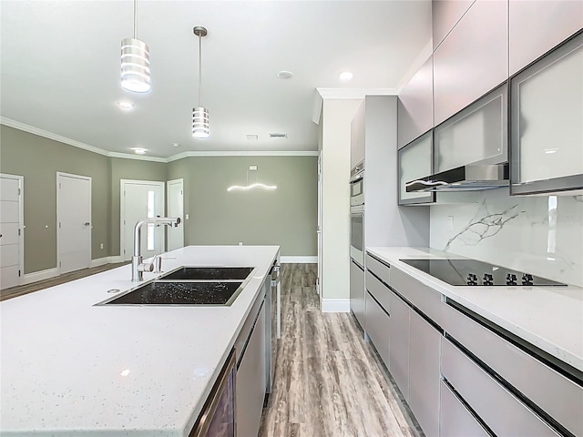 1870 Brentwood Ct, Davenport, FL 33837 - kitchen with black electric stovetop, a sink, ornamental molding, a large island, and light wood-type flooring