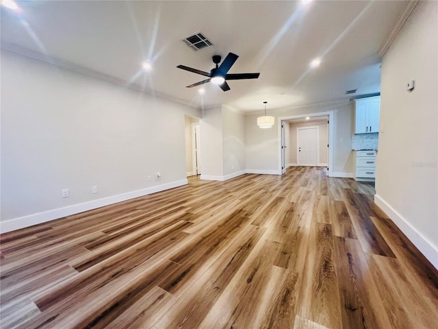 801 Leeward Way, Palm Harbor, FL 34685 - unfurnished living room featuring crown molding, ceiling fan, light wood finished floors, and baseboards