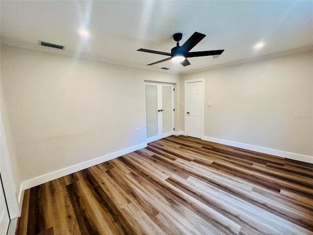 801 Leeward Way, Palm Harbor, FL 34685 - unfurnished bedroom with crown molding, wood finished floors, baseboards, a ceiling fan, and a closet