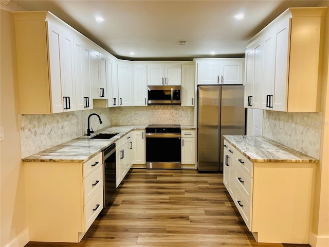 801 Leeward Way, Palm Harbor, FL 34685 - kitchen with stainless steel appliances, a sink, light wood-style flooring, light stone counters, and backsplash