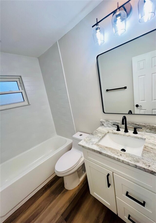 801 Leeward Way, Palm Harbor, FL 34685 - bathroom with vanity, wood finished floors, toilet, and washtub / shower combination
