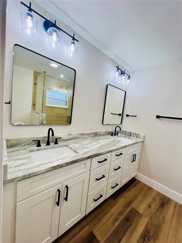 801 Leeward Way, Palm Harbor, FL 34685 - bathroom featuring double vanity, a stall shower, wood finished floors, and baseboards