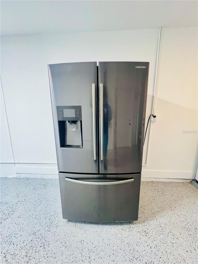 801 Leeward Way, Palm Harbor, FL 34685 - kitchen view of stainless steel refrigerator with ice dispenser, dark speckled floor, and baseboards
