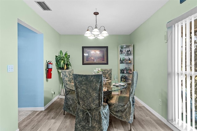1566 Providence Blvd, Deltona, FL 32725 - dining area featuring wood finished floors, healthy amount of natural light, and a chandelier