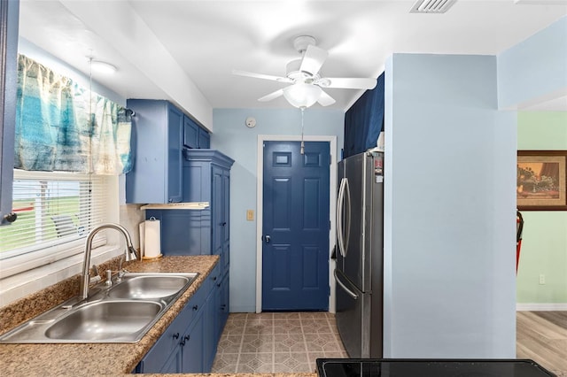 1566 Providence Blvd, Deltona, FL 32725 - kitchen with freestanding refrigerator, a sink, blue cabinetry, a ceiling fan, and baseboards