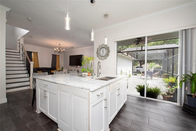 5231 Lemon Twist Ln, Windermere, FL 34786 - kitchen featuring white cabinets, a chandelier, light stone countertops, pendant lighting, and ornamental molding