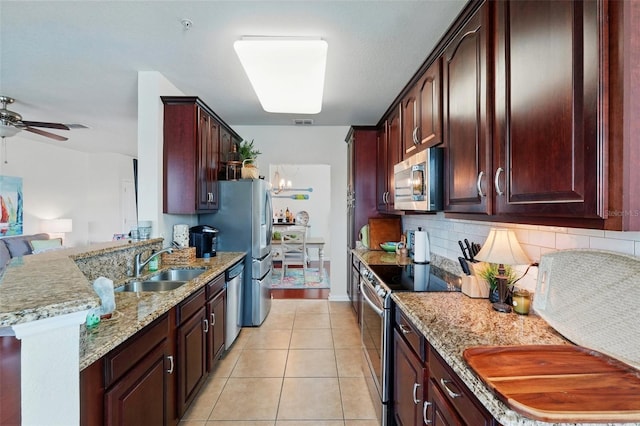 1225 Bella Cara Ct Unit 1, Davenport, FL 33896 - kitchen featuring stainless steel appliances, a sink, backsplash, light stone countertops, and light tile patterned flooring