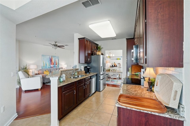 1225 Bella Cara Ct Unit 1, Davenport, FL 33896 - kitchen featuring stainless steel appliances, open floor plan, a sink, light tile patterned floors, and light stone countertops