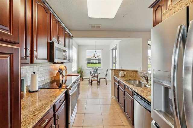 1225 Bella Cara Ct Unit 1, Davenport, FL 33896 - kitchen featuring stainless steel appliances, a sink, tasteful backsplash, light stone counters, and light tile patterned flooring