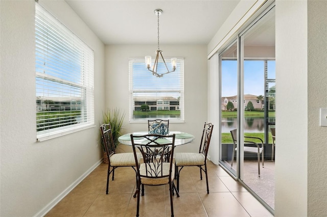 1225 Bella Cara Ct Unit 1, Davenport, FL 33896 - dining space featuring a chandelier, light tile patterned floors, a water view, and baseboards