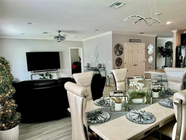 1016 Cascade Dr, Davenport, FL 33837 - dining space with crown molding, light wood-type flooring, a textured ceiling, and recessed lighting