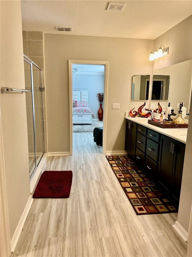 1016 Cascade Dr, Davenport, FL 33837 - bathroom with wood finished floors, a textured ceiling, vanity, and a stall shower