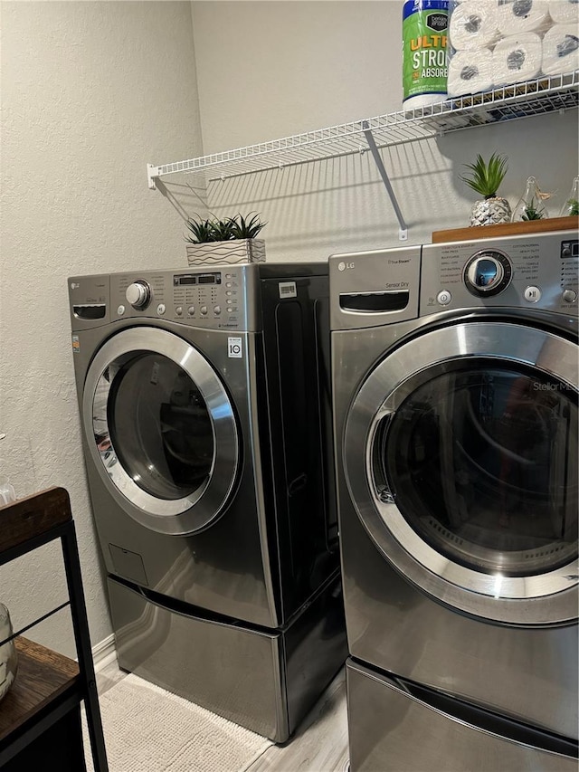 1016 Cascade Dr, Davenport, FL 33837 - laundry area with washing machine and clothes dryer and a textured wall