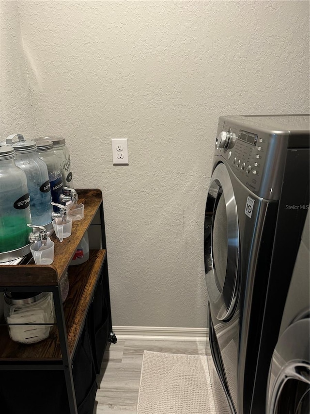 1016 Cascade Dr, Davenport, FL 33837 - washroom with light wood finished floors, a textured wall, and separate washer and dryer