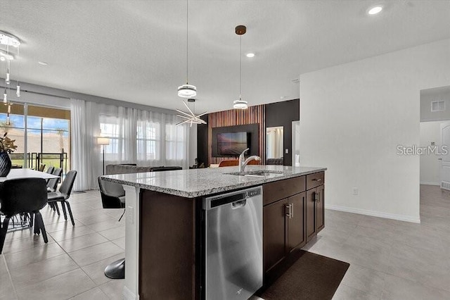 7622 Oakmoss Loop, Davenport, FL 33837 - kitchen with dishwasher, a sink, dark brown cabinets, a center island with sink, and light stone countertops