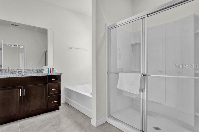 7622 Oakmoss Loop, Davenport, FL 33837 - bathroom featuring vanity, a garden tub, a shower stall, tile patterned floors, and baseboards
