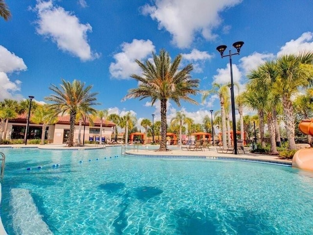 7622 Oakmoss Loop, Davenport, FL 33837 - community pool featuring a water slide and a patio
