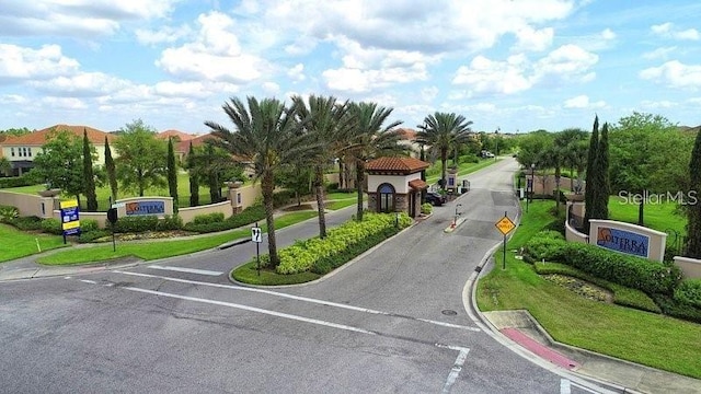 7622 Oakmoss Loop, Davenport, FL 33837 - view of asphalt street with curbs, traffic signs, a gated entry, and sidewalks