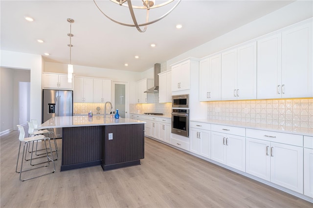 15600 Vetta Dr, Bella Collina, FL 34756 - kitchen with appliances with stainless steel finishes, wall chimney exhaust hood, white cabinets, backsplash, and light countertops