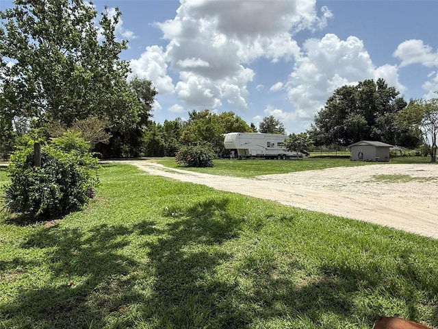 15311 Johns Lake Rd, Clermont, FL 34711 - view of green lawn with driveway and a storage shed