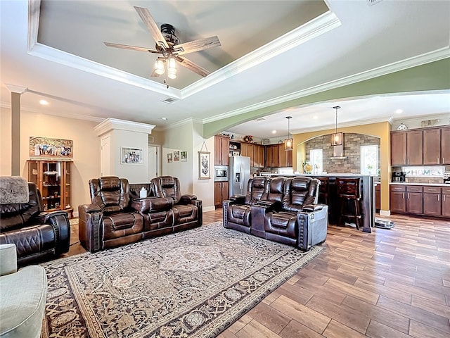 15311 Johns Lake Rd, Clermont, FL 34711 - living area featuring arched walkways, a raised ceiling, ceiling fan, light wood-type flooring, and ornamental molding