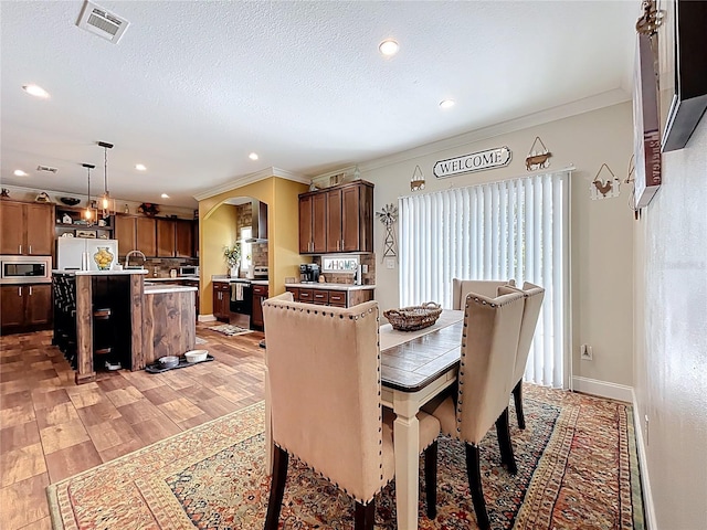 15311 Johns Lake Rd, Clermont, FL 34711 - dining space with arched walkways, ornamental molding, light wood-style flooring, recessed lighting, and baseboards