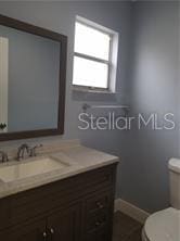 5144 Picadilly Circus Ct Unit 2, Orlando, FL 32839 - half bathroom with vanity, toilet, and baseboards