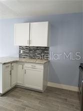 5144 Picadilly Circus Ct Unit 2, Orlando, FL 32839 - kitchen with decorative backsplash, baseboards, light countertops, and wood finished floors