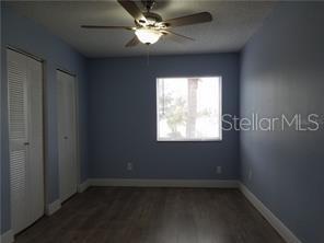 5144 Picadilly Circus Ct Unit 2, Orlando, FL 32839 - unfurnished bedroom with multiple closets, wood finished floors, baseboards, and a ceiling fan