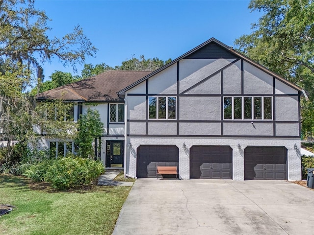 11951 Elbert St, Clermont, FL 34711 - tudor home featuring an attached garage, stucco siding, concrete driveway, a front lawn, and brick siding