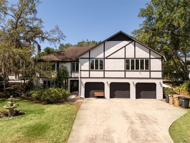 11951 Elbert St, Clermont, FL 34711 - english style home with stucco siding, a garage, concrete driveway, and a front yard
