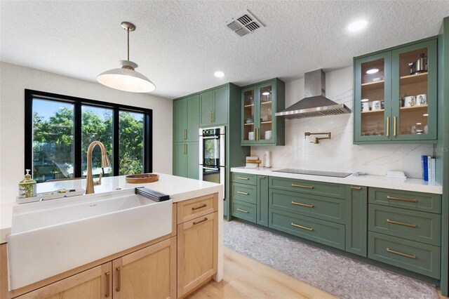 11951 Elbert St, Clermont, FL 34711 - kitchen with wall chimney exhaust hood, green cabinets, light countertops, black electric stovetop, and recessed lighting