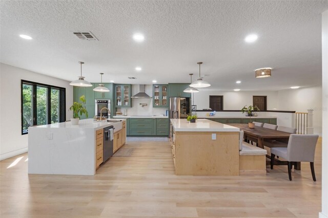 11951 Elbert St, Clermont, FL 34711 - kitchen featuring stainless steel appliances, a large island with sink, wall chimney range hood, recessed lighting, and light wood-type flooring