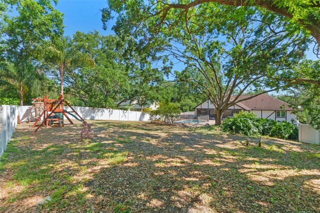 11951 Elbert St, Clermont, FL 34711 - fenced backyard featuring a playground