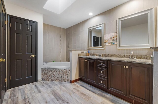 11951 Elbert St, Clermont, FL 34711 - bathroom featuring a bath, double vanity, wood finished floors, and a skylight
