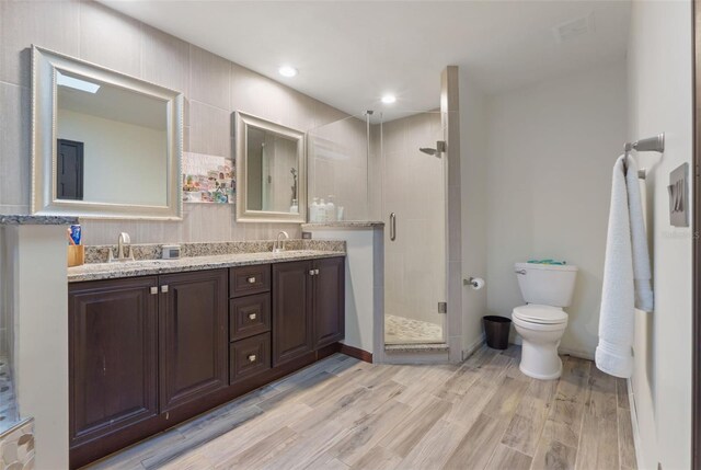 11951 Elbert St, Clermont, FL 34711 - bathroom featuring a shower stall, double vanity, wood finished floors, and recessed lighting