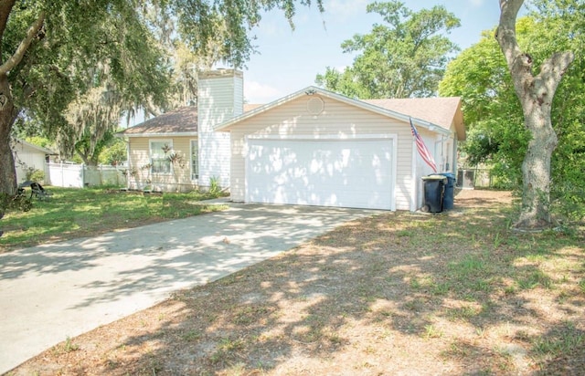7410 Orange Crest Cir, Lakeland, FL 33810 - view of front of home featuring driveway, an attached garage, and a chimney