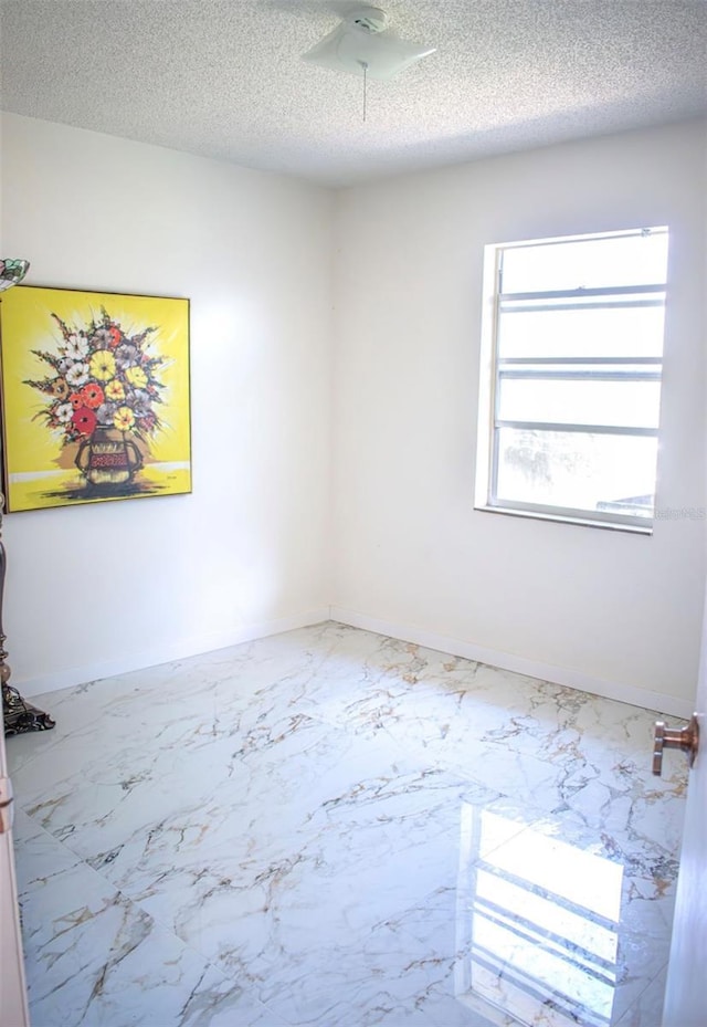7410 Orange Crest Cir, Lakeland, FL 33810 - unfurnished room with a textured ceiling, baseboards, and marble finish floors