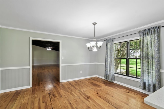 16 Pine Forest Dr, Haines City, FL 33844 - unfurnished dining area featuring a chandelier, ornamental molding, wood-type flooring, plenty of natural light, and wainscoting