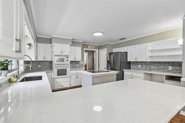 16 Pine Forest Dr, Haines City, FL 33844 - kitchen with white appliances, open shelves, tasteful backsplash, a kitchen island, and light stone countertops