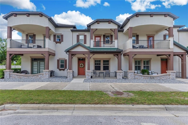 5103 Jones Rd, Saint Cloud, FL 34771 - view of front facade with stucco siding, a balcony, french doors, and covered porch
