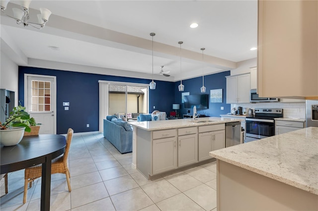 5103 Jones Rd, Saint Cloud, FL 34771 - kitchen featuring appliances with stainless steel finishes, open floor plan, backsplash, hanging light fixtures, and light tile patterned floors