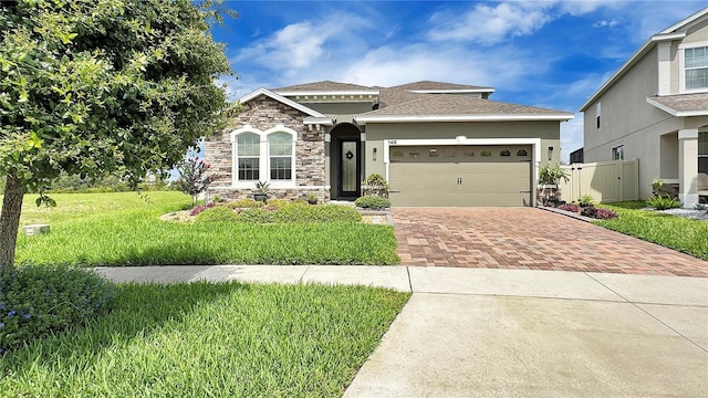 148 Whirlaway Dr, Davenport, FL 33837 - view of front of property featuring decorative driveway, an attached garage, stone siding, stucco siding, and roof with shingles
