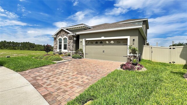 148 Whirlaway Dr, Davenport, FL 33837 - ranch-style home with decorative driveway, an attached garage, a gate, stone siding, and stucco siding