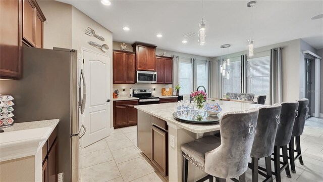 148 Whirlaway Dr, Davenport, FL 33837 - kitchen featuring appliances with stainless steel finishes, pendant lighting, a center island with sink, a breakfast bar area, and recessed lighting